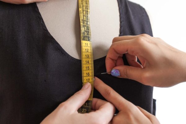 A Person Putting a Pin on a Black Dress