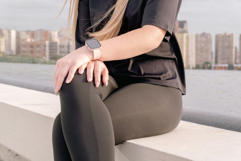 Woman in black leggings and t-shirt sitting outdoors